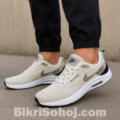 Nike Air Zoom running shoes in a light beige/tan colorway wi